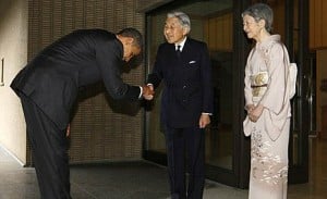 Obama haciendo una reverencia mientras estrecha la mano del Emperador de Japón