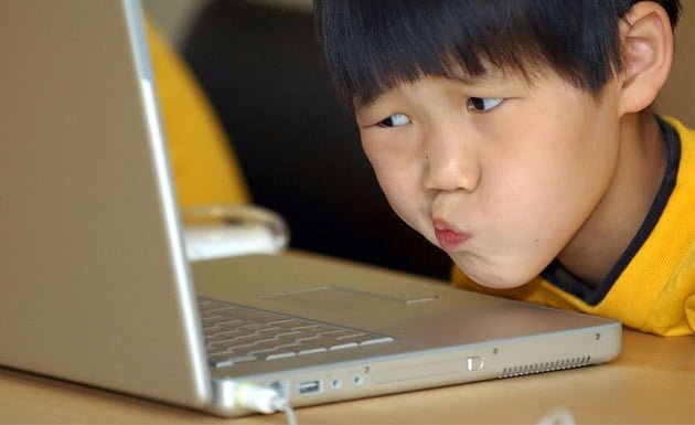 niño asiático en la computadora